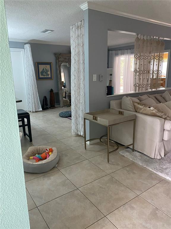 A bright entryway features light blue walls, tile flooring, a floral painting, and a white door — 1833 OAK VIEW DRIVE, SARASOTA, FL