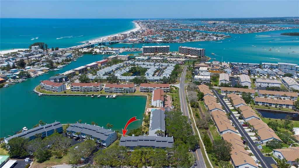 An aerial view shows a multi-story residential complex situated along a waterfront canal — 12140 CAPRI CIRCLE S UNIT 709, TREASURE ISLAND, FL