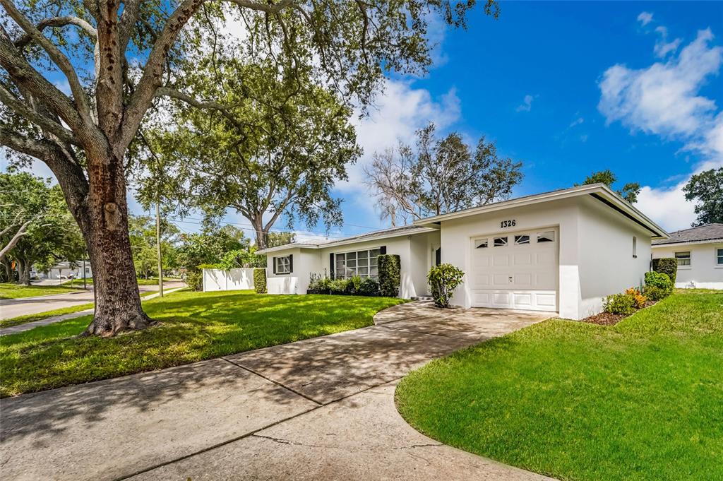 A white single-story house with a garage and a large tree in the front yard — 1326 ST THOMAS DRIVE, CLEARWATER, FL