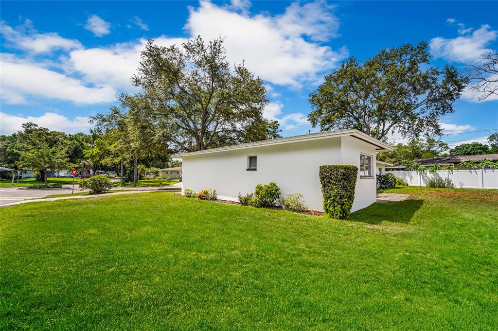 A white detached garage sits on a grassy lawn under a blue sky — 1326 ST THOMAS DRIVE, CLEARWATER, FL