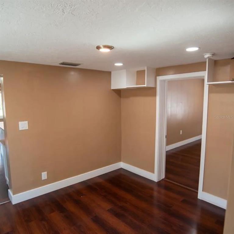 An interior room features tan walls, dark hardwood floors, recessed lighting, and white trim — 1329 34TH AVENUE N, ST PETERSBURG, FL