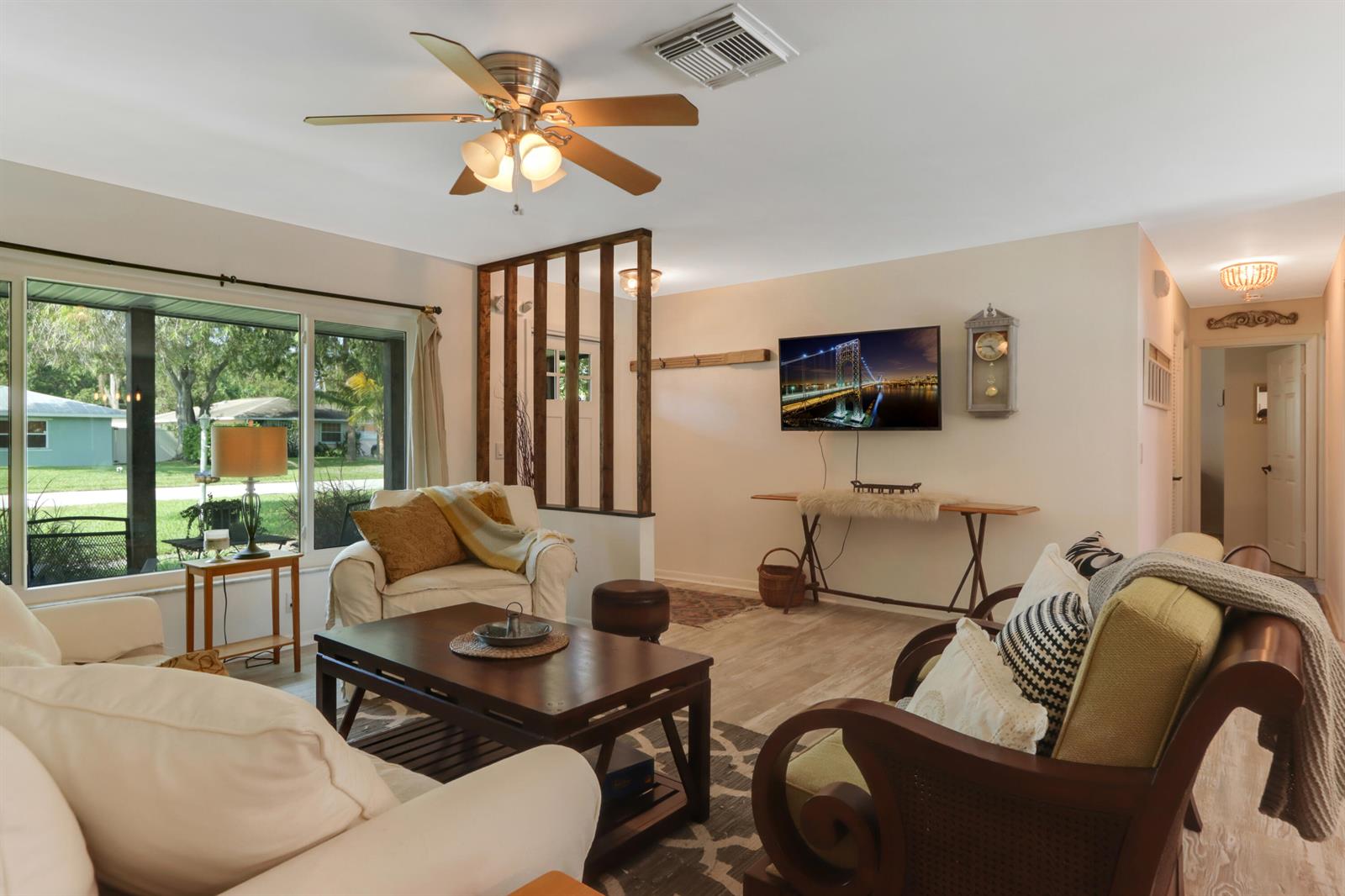 A living room features a ceiling fan, a wall-mounted television, and a wooden room divider — 186 23rd Avenue, Vero Beach FL 32962, VERO BEACH, FL