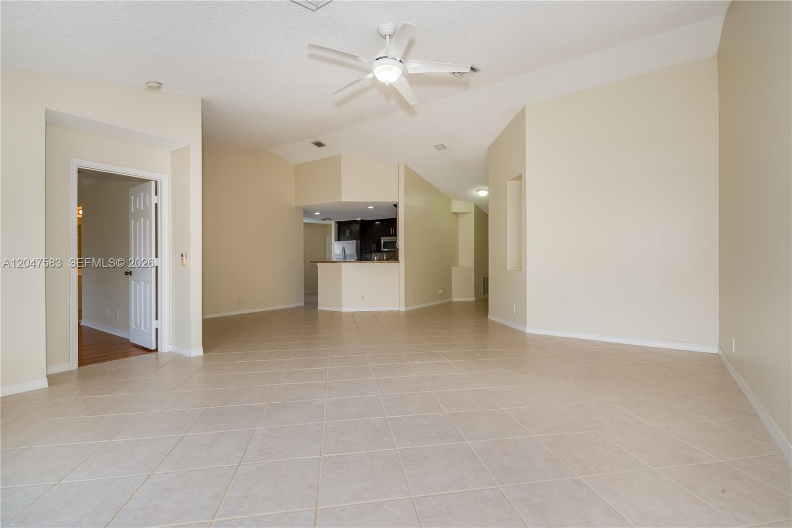 An open-concept living area features beige tile flooring, vaulted ceilings, and a kitchen pass-through — 4152 Pine Ridge Ln # 0, Weston FL 33331, WESTON, FL