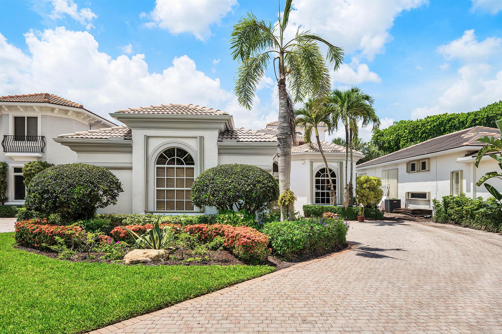 A white house with a tiled roof, palm trees, and a paved driveway — 7917 Villa D Este Way, Delray Beach FL 33446, DELRAY BEACH, FL