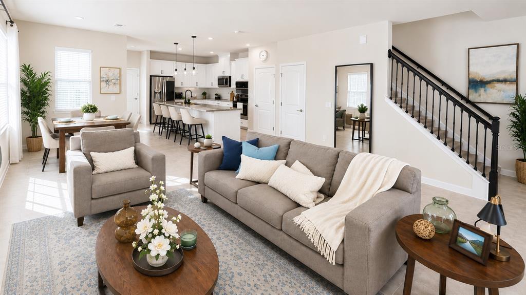 An open-concept living room and kitchen area features a sofa, dining table, and island — 3974 GREAT SMOKEY WAY, APOPKA, FL
