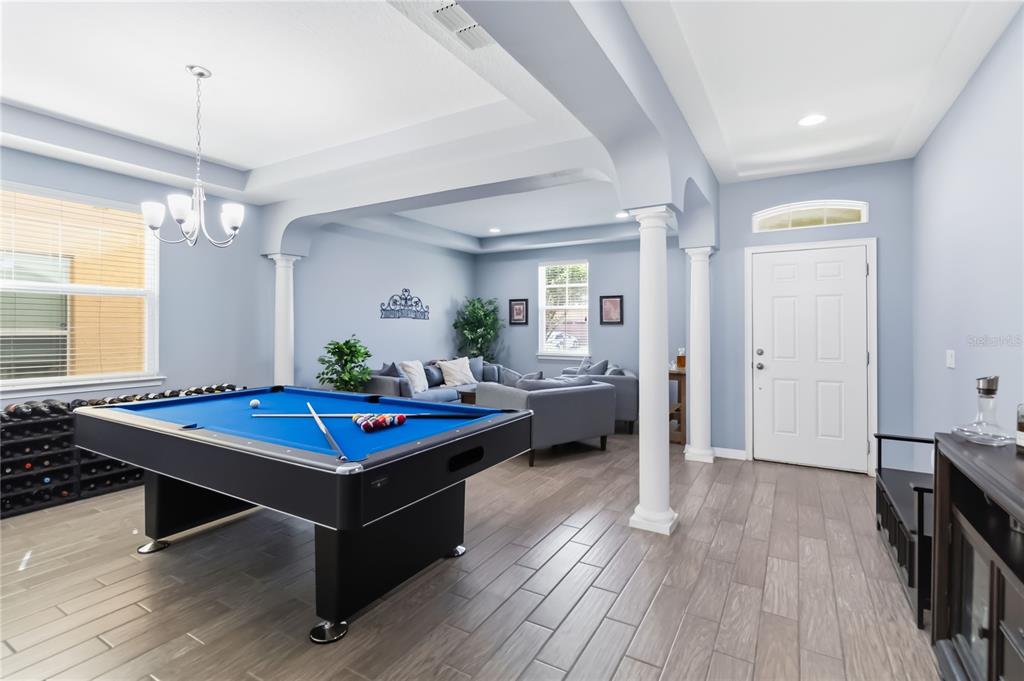 A game room features a blue pool table, gray tile flooring, and white columns — 5053 TORCHWOOD DRIVE, MINNEOLA, FL