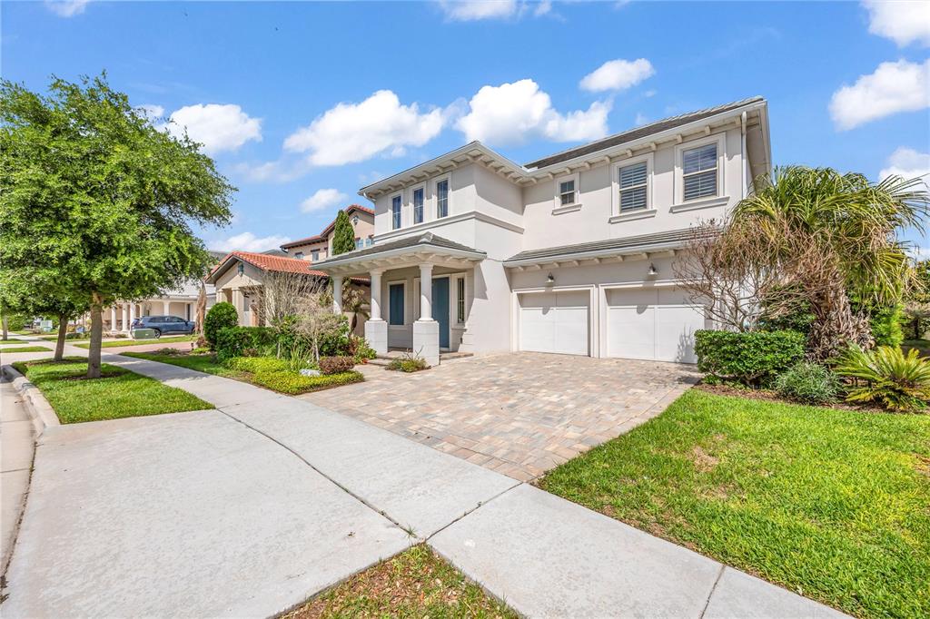 A two-story house with a paved driveway, two-car garage, and a covered front porch — 15594 SHOREBIRD LANE, WINTER GARDEN, FL
