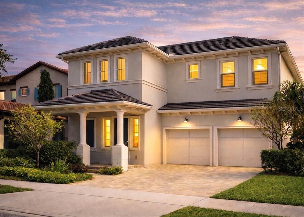 A two-story suburban house with a paved driveway, a two-car garage, and a covered porch — 15594 SHOREBIRD LANE, WINTER GARDEN, FL