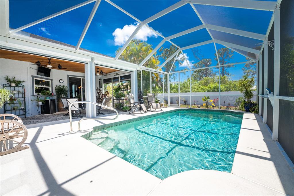 A screened-in swimming pool area with a patio and outdoor seating under a vaulted ceiling — 15105 ALDAMA CIRCLE, PORT CHARLOTTE, FL