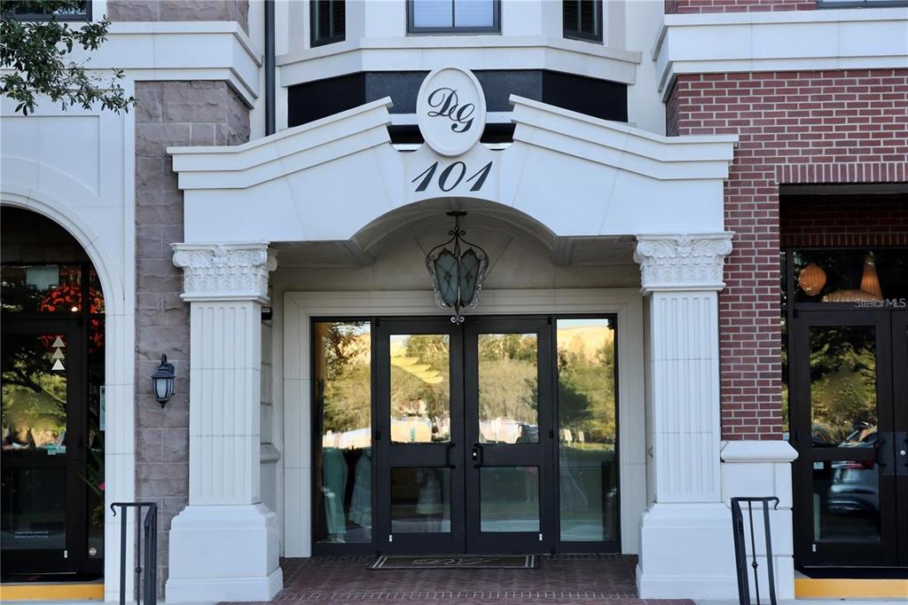 The exterior entrance of a building features a stone portico with a decorative monogram sign — 330 W MORSE BLVD UNIT 104, WINTER PARK, FL