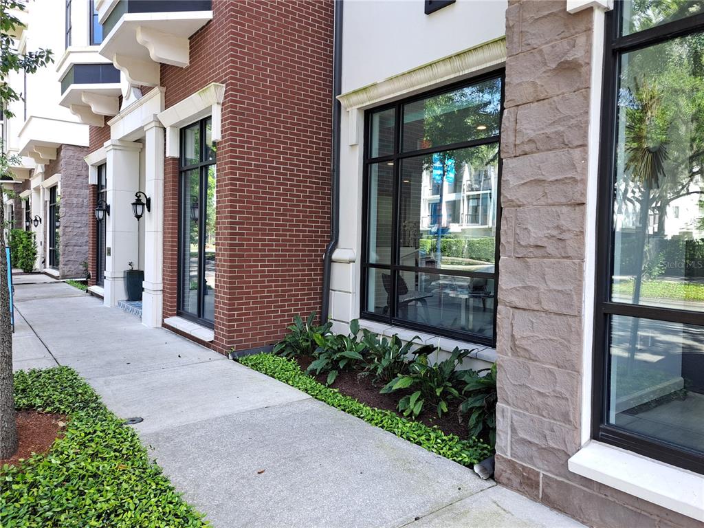 A sidewalk runs along the exterior of a building featuring brick, stone, and large windows — 330 W MORSE BLVD UNIT 104, WINTER PARK, FL