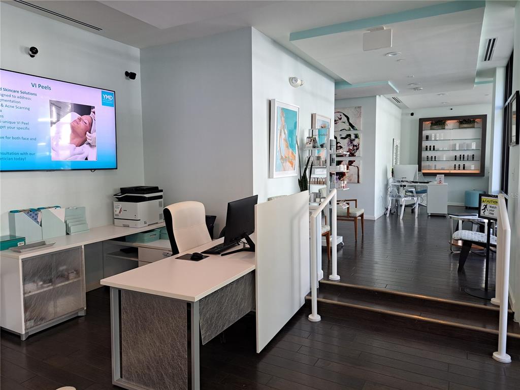 A reception area features a desk, a television screen, and stairs leading to another room — 330 W MORSE BLVD UNIT 104, WINTER PARK, FL