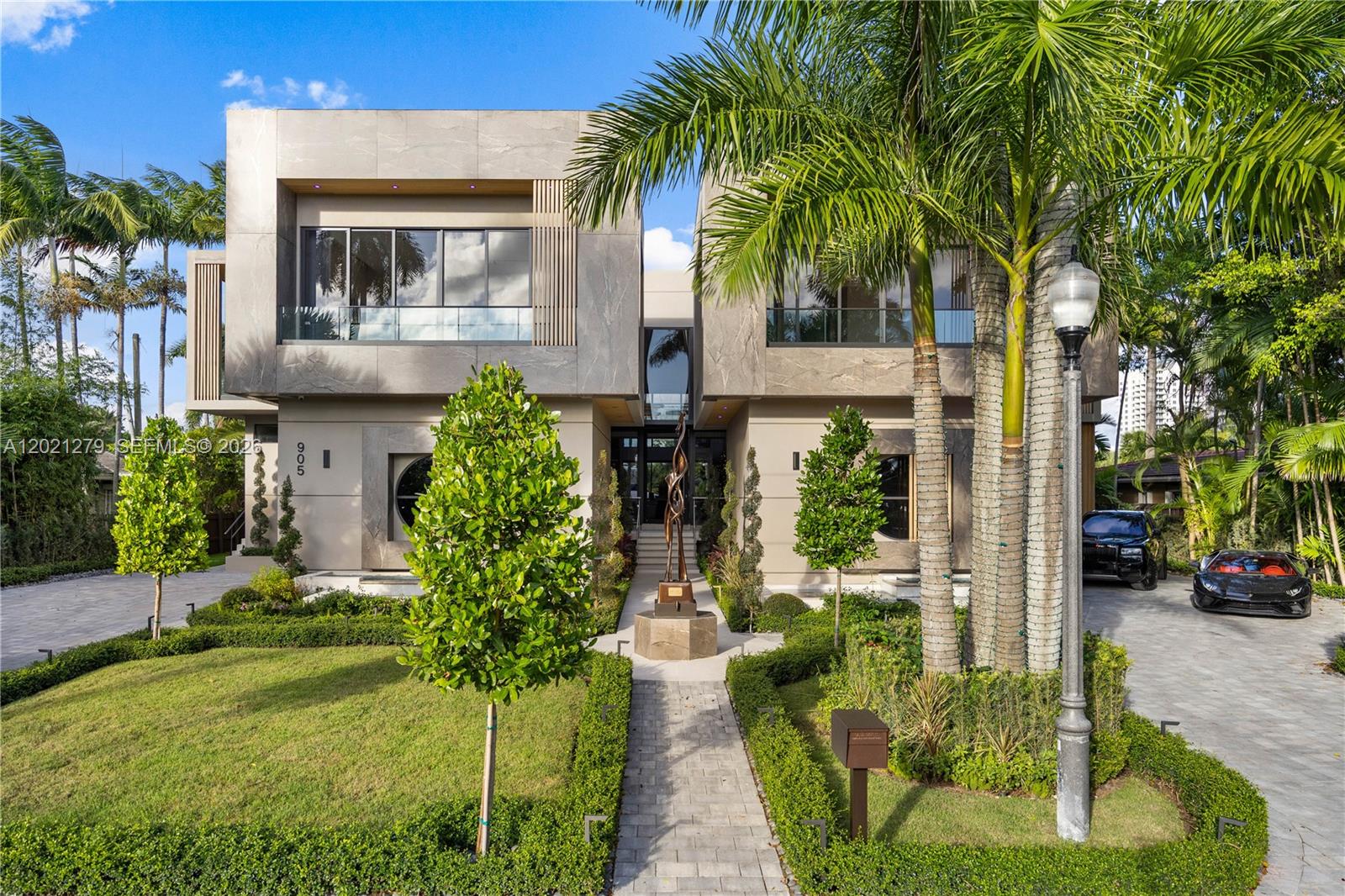 A modern two-story house features a stone facade, palm trees, and a landscaped front yard — 905 Belle Meade Island Dr, Miami FL 33138, MIAMI, FL