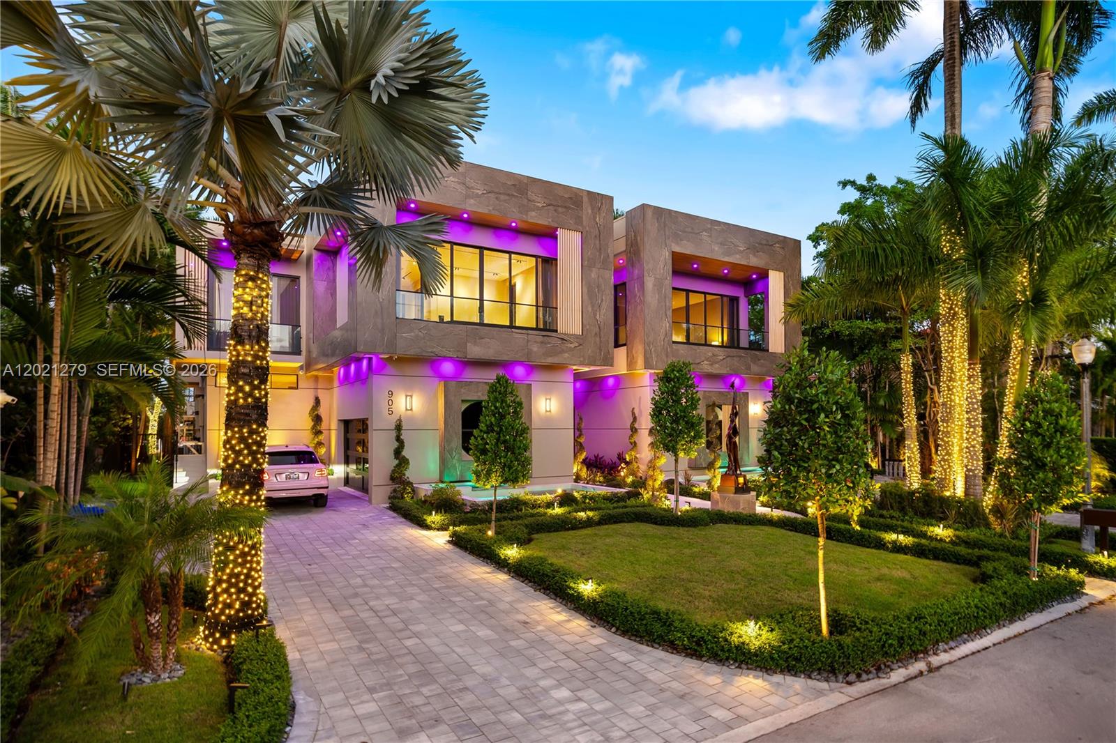 A modern two-story house features stone cladding, purple accent lighting, and a landscaped front yard — 905 Belle Meade Island Dr, Miami FL 33138, MIAMI, FL