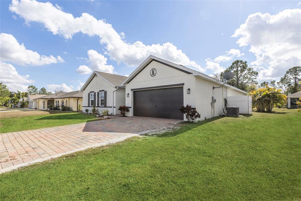 A single-story house with a paved driveway, a two-car garage, and a large front lawn — 25099 BOLIVAR DRIVE, PUNTA GORDA, FL