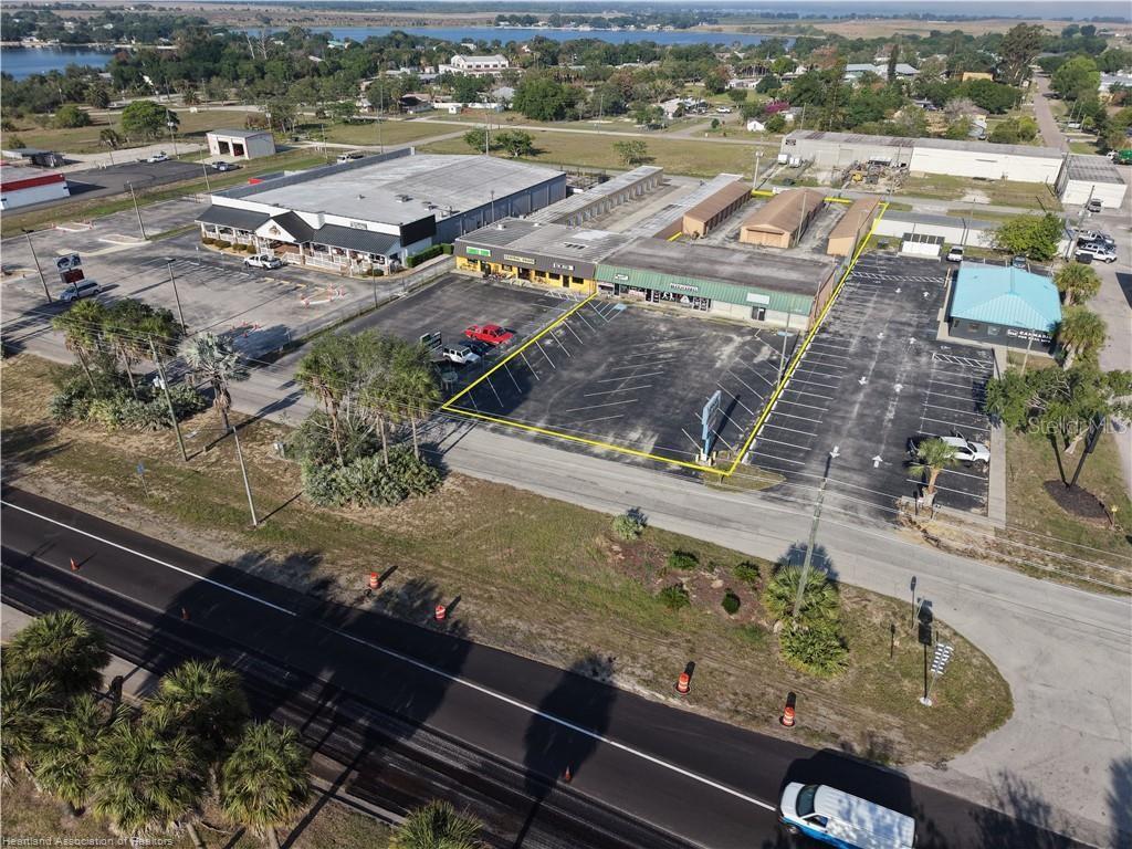 An aerial view shows a commercial strip mall with a large parking lot — 708 US 27 S, LAKE PLACID, FL