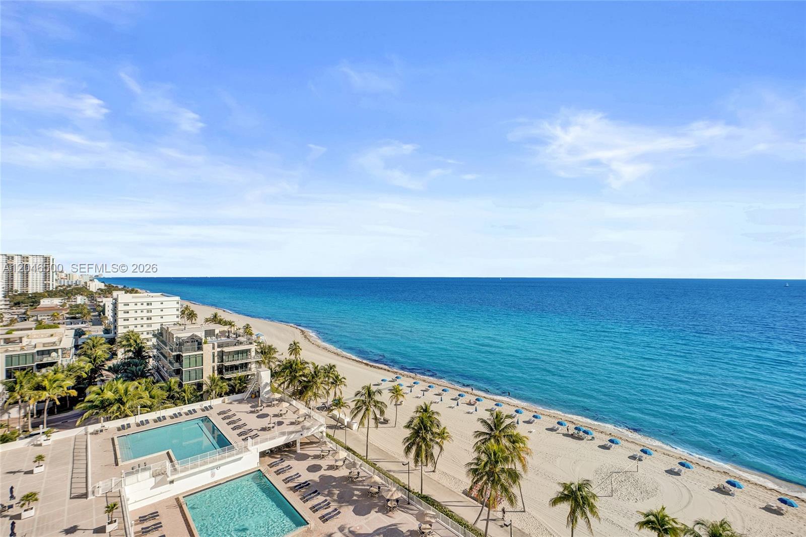 An aerial view shows a beach with two swimming pools and palm trees — 2301 S Ocean Dr # 1004, Hollywood FL 33019, HOLLYWOOD, FL