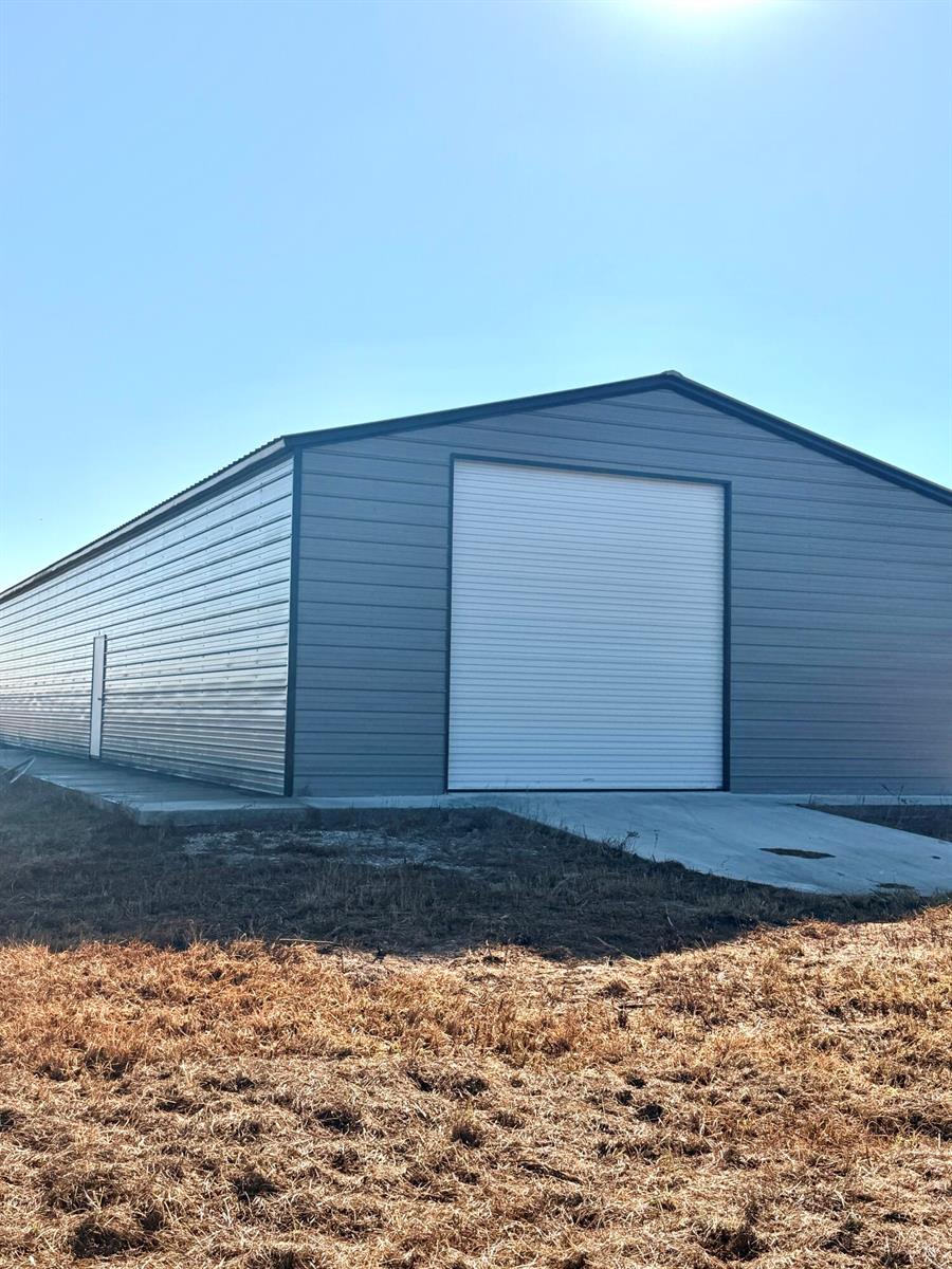 A gray metal building with a white roll-up door and a side entry door — 3970 NE 80th Avenue, Okeechobee FL 34972, OKEECHOBEE, FL