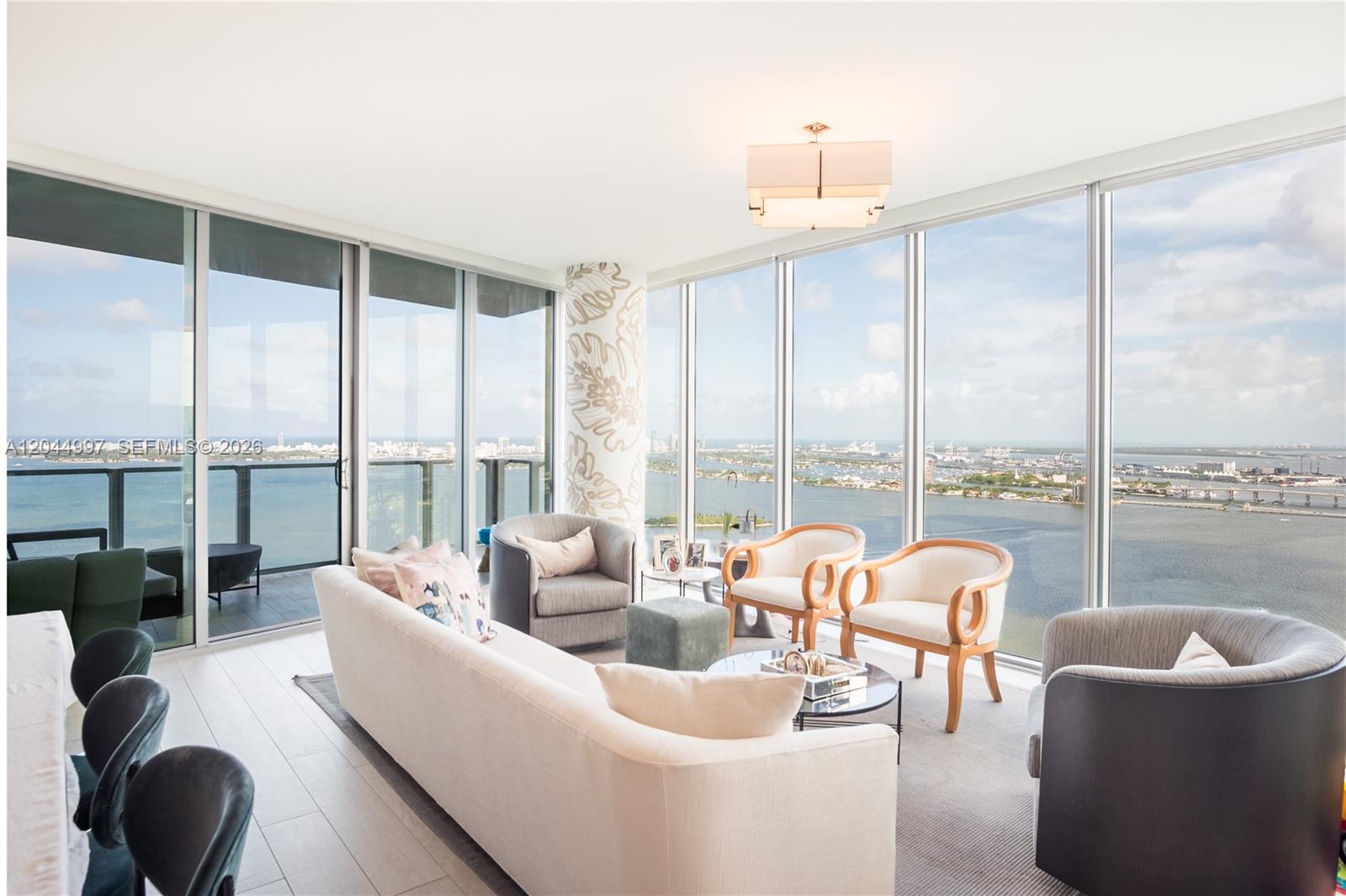 A living room with floor-to-ceiling windows, a white sofa, and views of the water — 2900 NE 7th Ave # 4307, Miami FL 33137, MIAMI, FL