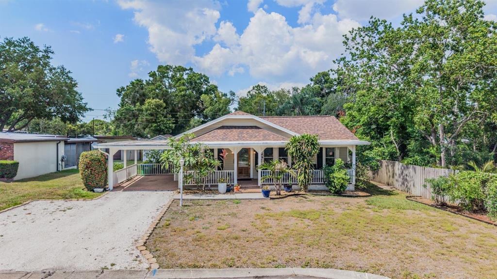 A single-story house with a front porch, a carport, and a gravel driveway — 1618 OTTAWA ROAD, CLEARWATER, FL