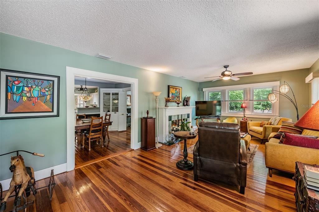 A living room with hardwood floors, a fireplace, and an arched doorway leading to a dining room — 1618 OTTAWA ROAD, CLEARWATER, FL