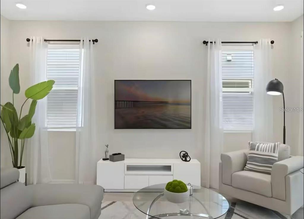 A living room features a wall-mounted television, white media console, two windows, and neutral furniture — 1929 TROPICAL PALMS CIRCLE, KISSIMMEE, FL