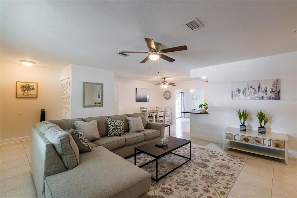 A living room features a sectional sofa, coffee table, area rug, and an adjacent dining area — 95 S BRIGGS AVENUE, SARASOTA, FL