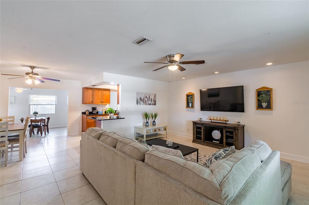 A living room with a sectional sofa, television, and an adjacent dining area — 95 S BRIGGS AVENUE, SARASOTA, FL