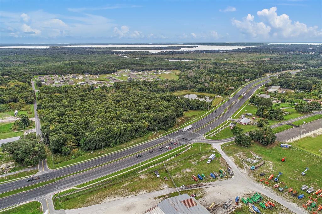 An aerial view shows a multi-lane highway intersecting a rural area with forests and housing — 2631 US-441, FRUITLAND PARK, FL