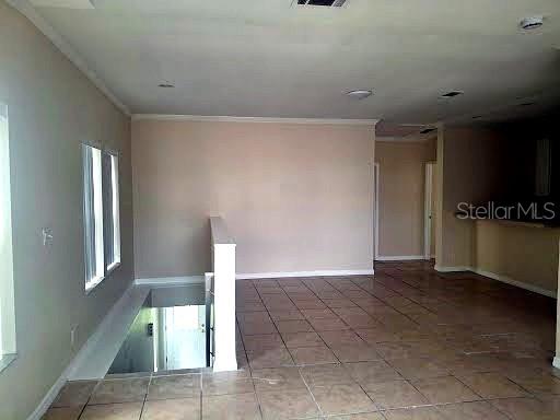 An interior view of a room with tiled floors, a staircase, and a doorway — 4853 ANCHORAGE COVE, PORT RICHEY, FL