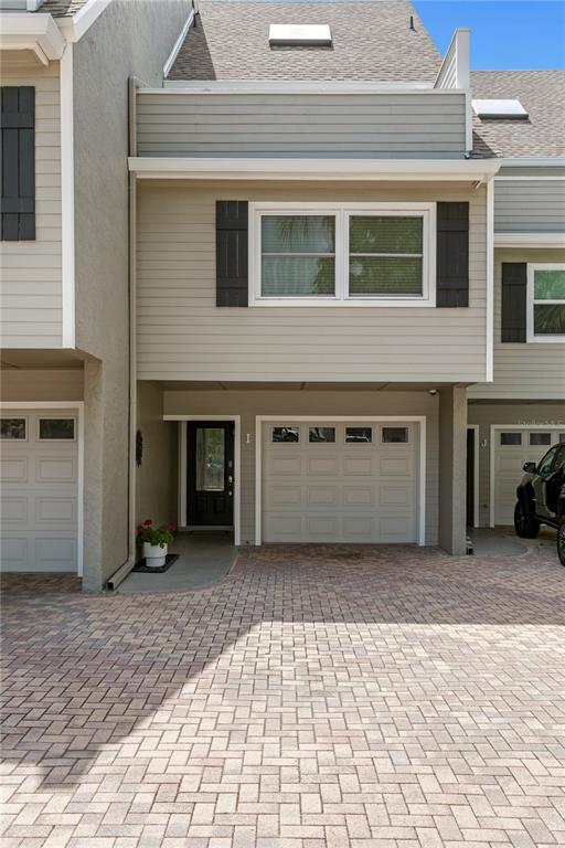 A multi-story townhouse exterior features a brick driveway, a garage, and a front entrance — 360 PINELLAS BAYWAY S UNIT I, TIERRA VERDE, FL