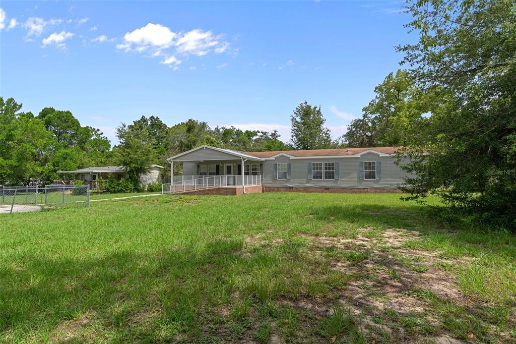 A single-story manufactured home with a front porch and wheelchair ramp sits on a grassy lot — 7351 W HADENOTTER LANE, HOMOSASSA, FL