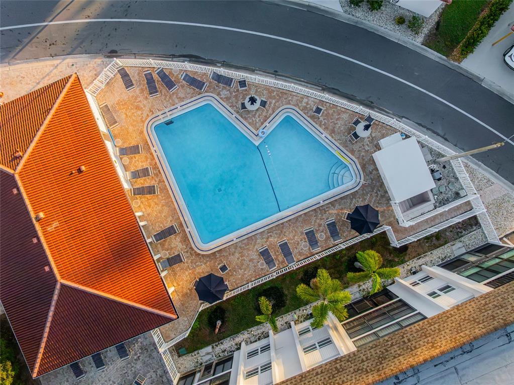 An aerial view shows a swimming pool with lounge chairs on a paved patio deck — 116 VISTA HERMOSA CIRCLE UNIT 204C, SARASOTA, FL