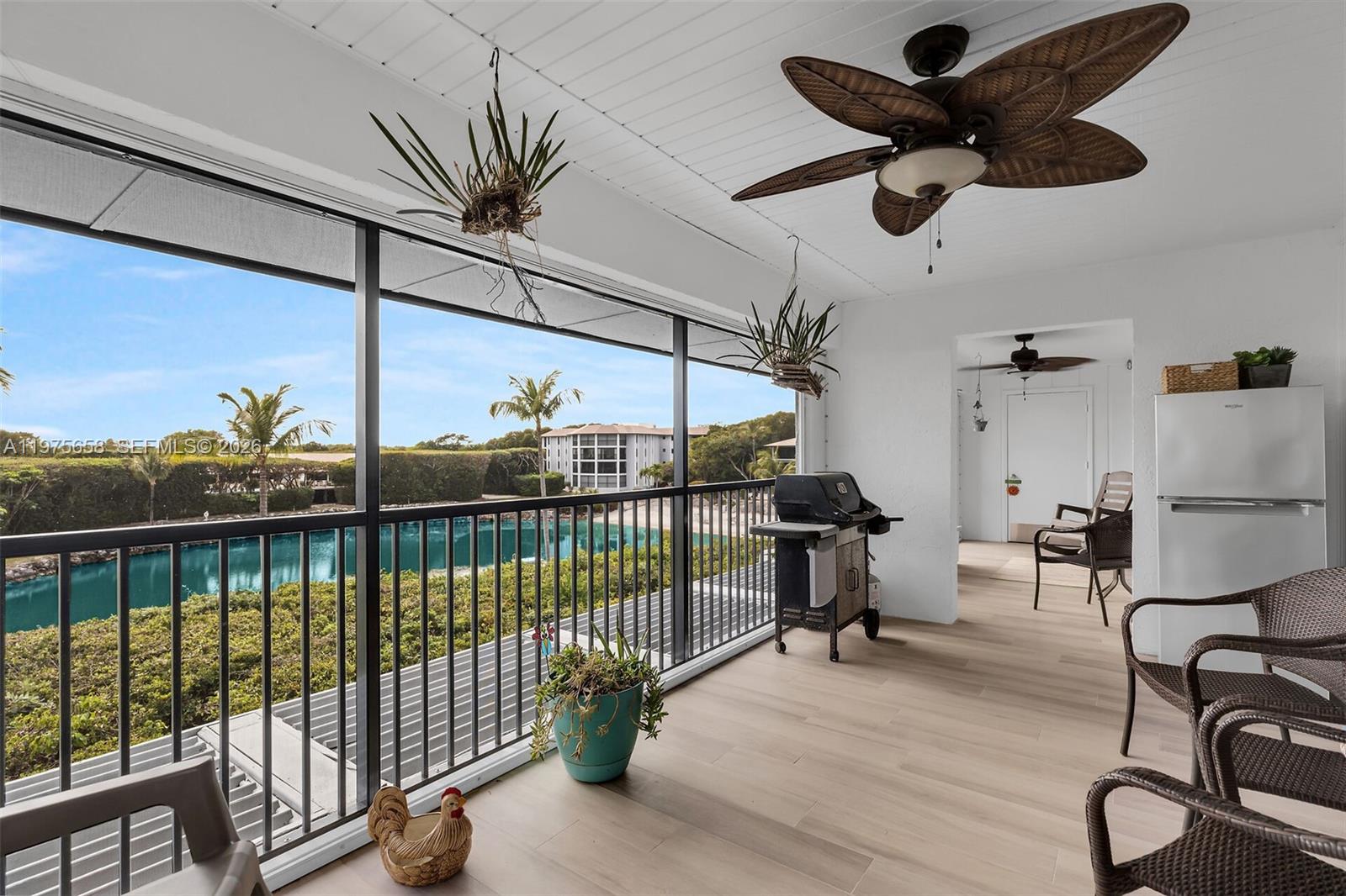 Huge screened in porch with lots of space for seating and dining options. Views overlooking the ocean and the pond with sandy beach — ISLAMORADA, FL