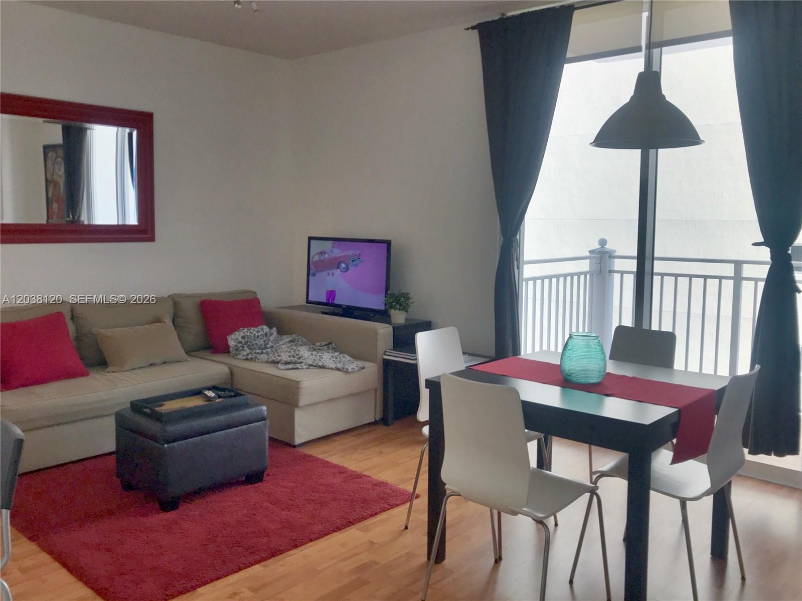 A living and dining area features a sectional sofa, a television, and a dining set — 185 SE 14th Ter # 1401, Miami FL 33131, MIAMI, FL