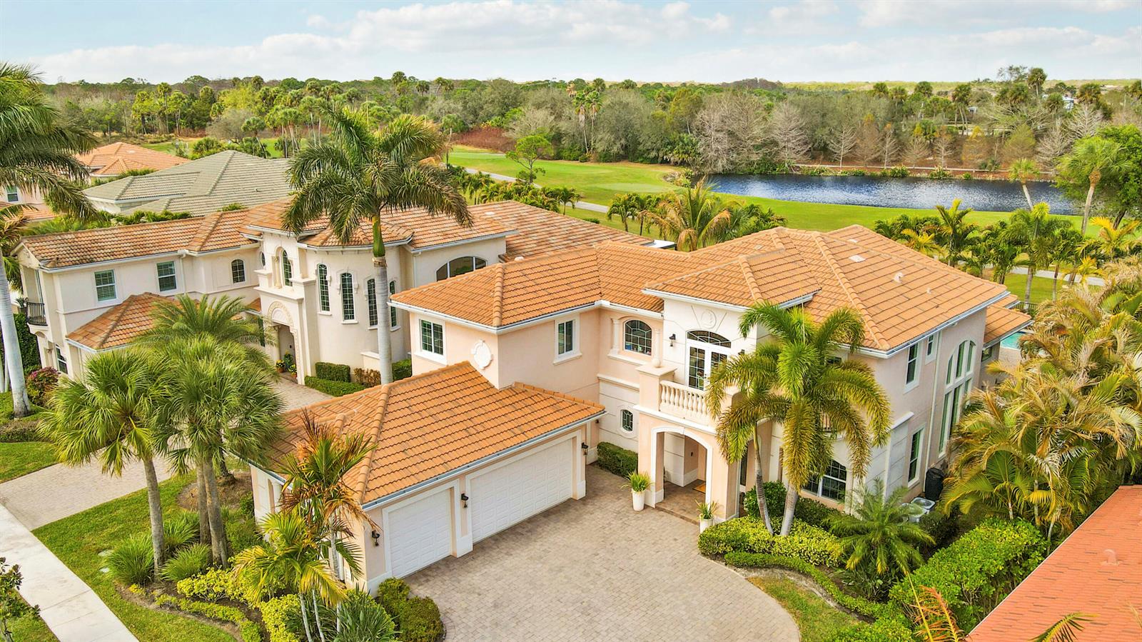 An aerial view of a two-story stucco house with a tiled roof and palm trees — 167 Rosalia Court S, Jupiter FL 33478, JUPITER, FL