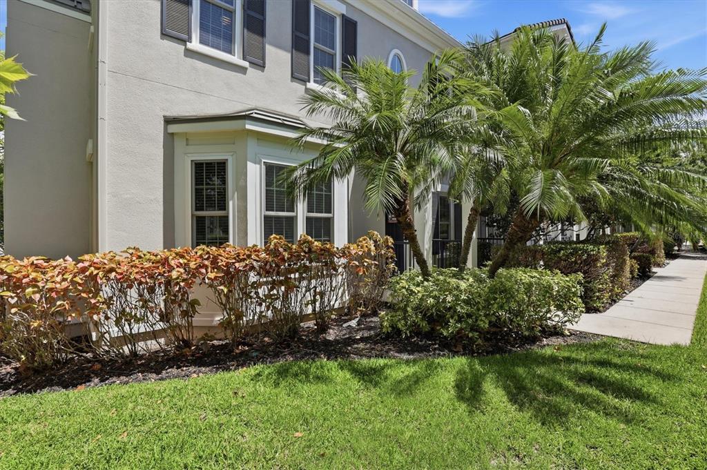 The exterior of a two-story house features a bay window, palm trees, and landscaping — 480 GILMAN PLACE N, ST PETERSBURG, FL