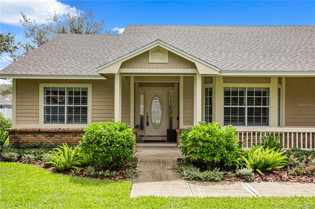A tan, single-story house with a gabled entryway, brick accents, and a front walkway — 5410 RUSTIC PINE COURT, ORLANDO, FL