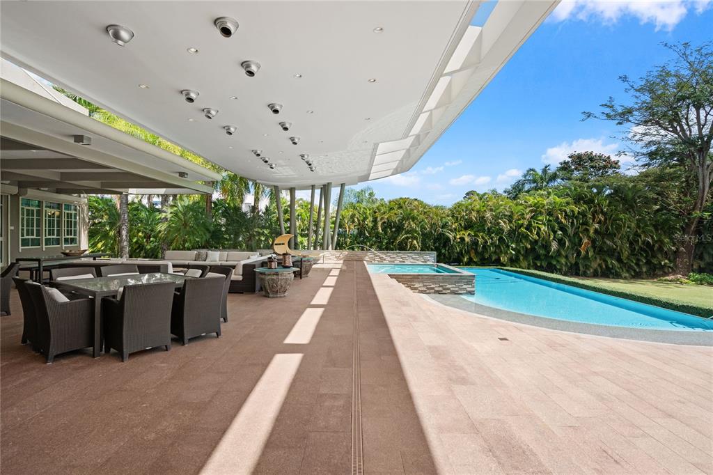 A spacious covered patio features outdoor dining and lounge furniture next to a swimming pool — 9 CASTAÑA STREET, GUAYNABO, PR