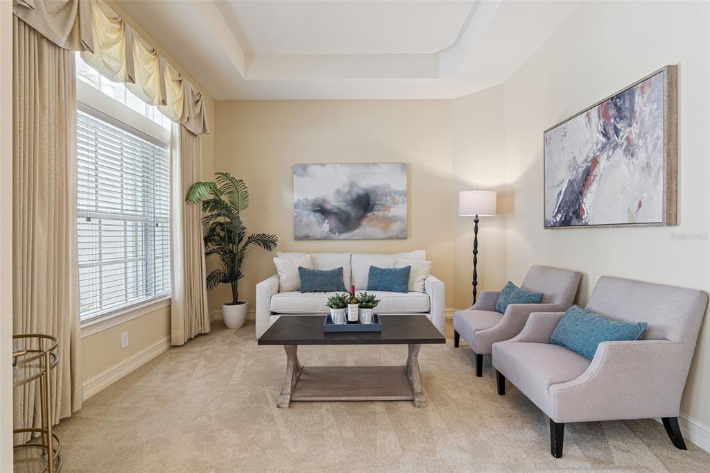 A living room features a sofa, two armchairs, a coffee table, and two wall paintings — 112 BELLINGRATH TERRACE, DELAND, FL