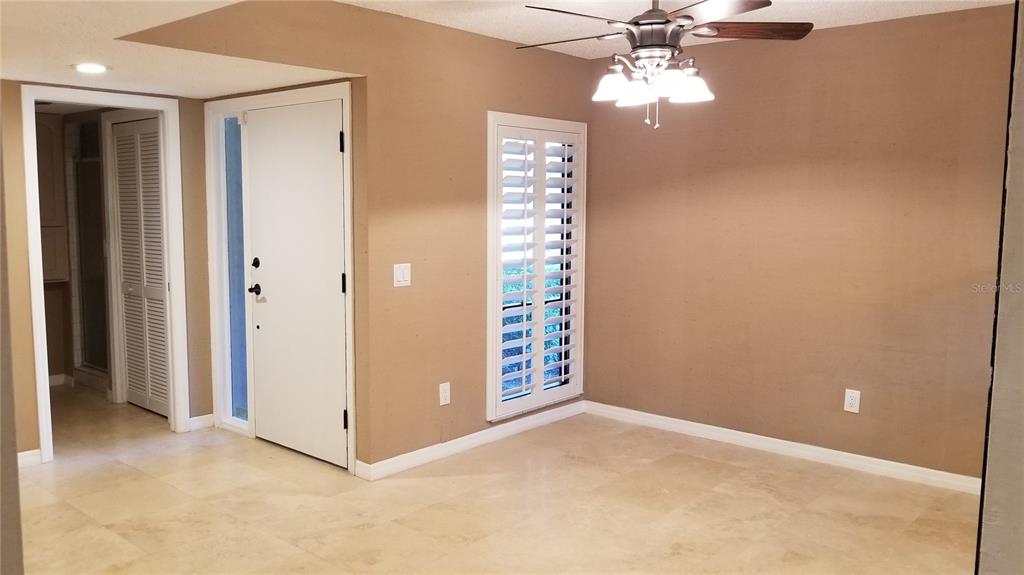 A room with tan walls, tile flooring, a ceiling fan, and a white door — 104 OLD MILL POND ROAD, PALM HARBOR, FL