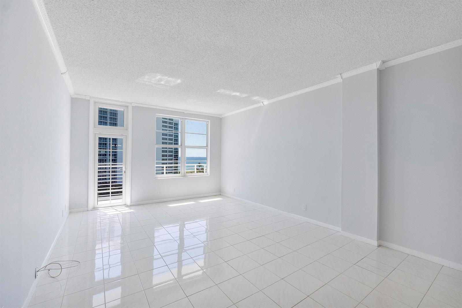 An empty room with white tile floors, white walls, and a view of the ocean — 2851 S Ocean Boulevard, Boca Raton FL 33432, BOCA RATON, FL