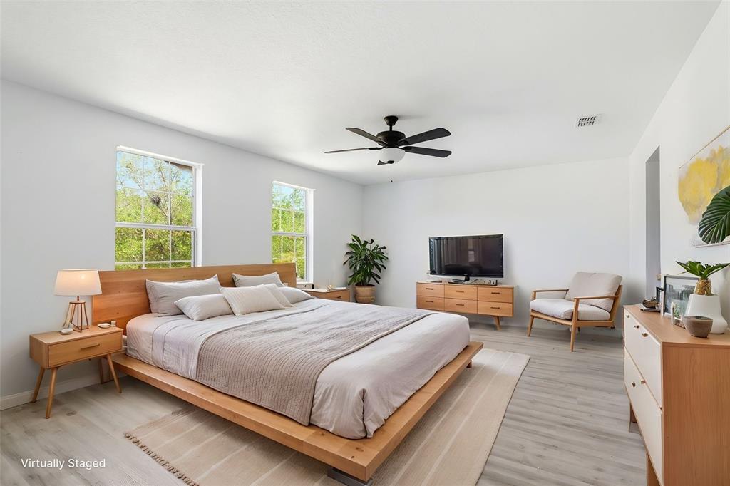 A bedroom features a wooden platform bed, light wood furniture, and a ceiling fan — 3356 SLATE STREET, WEST MELBOURNE, FL