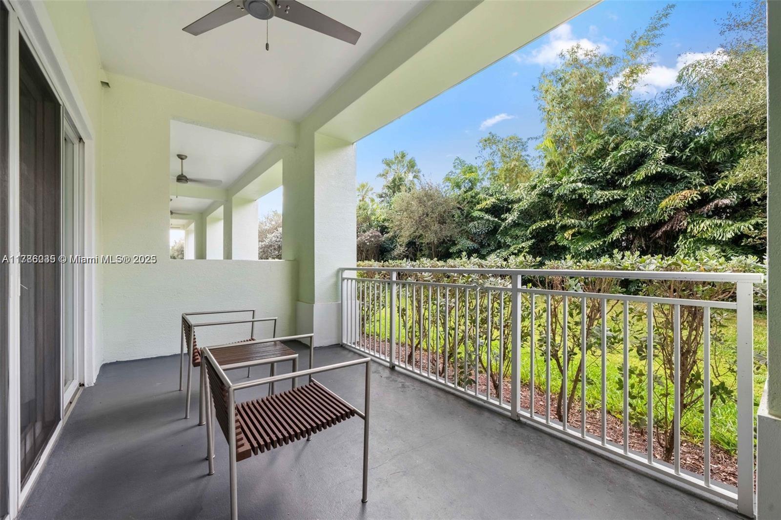 A covered balcony features two modern chairs, a ceiling fan, and a metal railing — 5300 NW 87th Ave # 115, Doral FL 33178, DORAL, FL