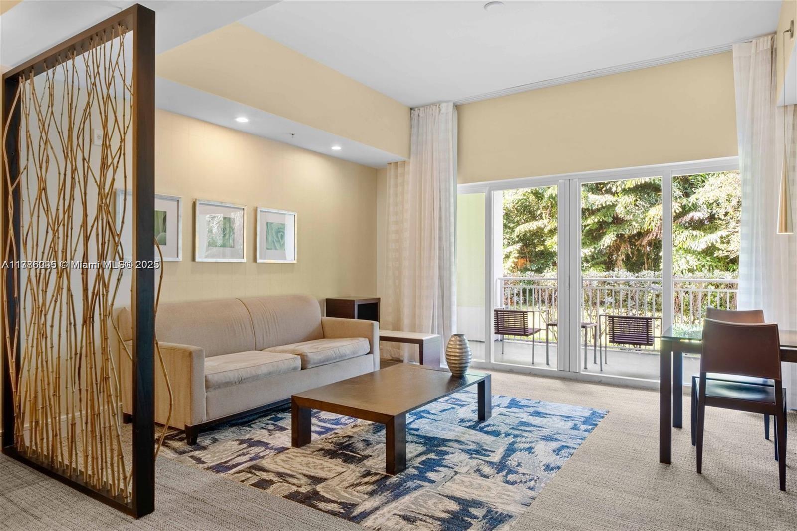 A living room features a beige sofa, a wooden coffee table, and a decorative bamboo screen — 5300 NW 87th Ave # 115, Doral FL 33178, DORAL, FL