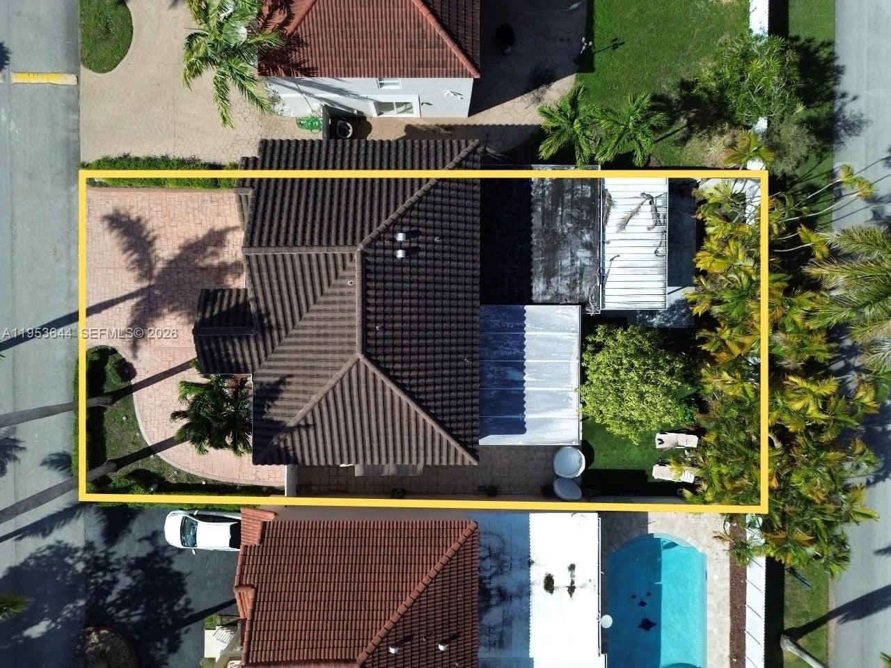 An aerial view shows a house with a tiled roof, a paved driveway, and backyard — 12415 NW 7th St, Miami FL 33182, MIAMI, FL