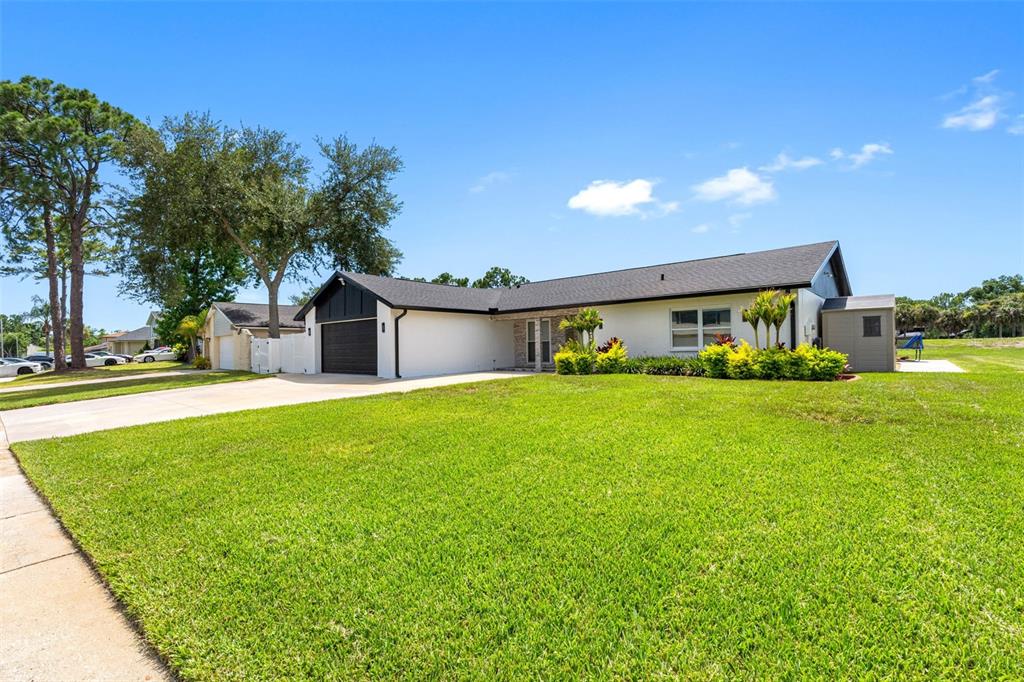 A single-story house with a dark roof, white exterior, and a two-car garage — 16206 W COURSE DRIVE, TAMPA, FL
