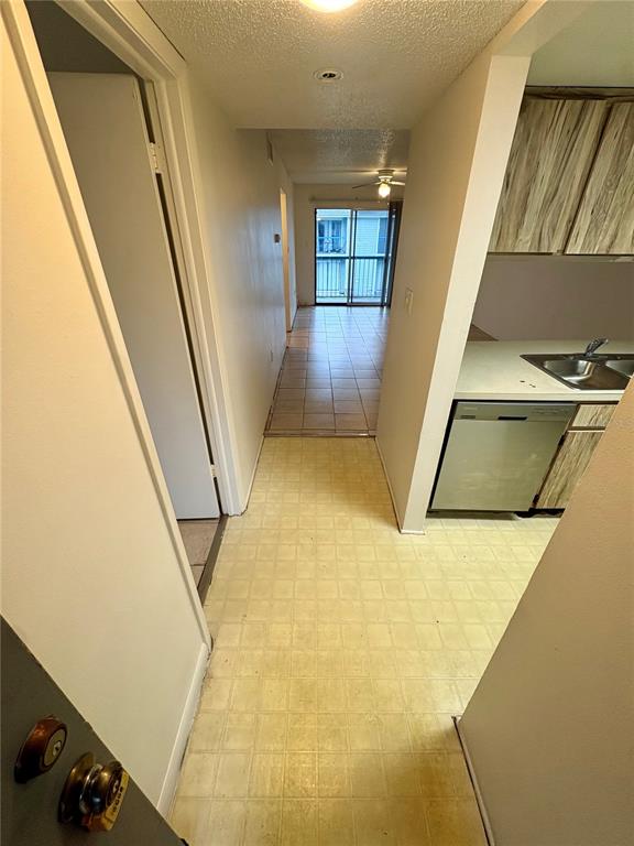 A view from a doorway looking into a kitchen with a dishwasher and tiled hallway — 5038 TERRACE PALMS CIRCLE UNIT 202, TAMPA, FL