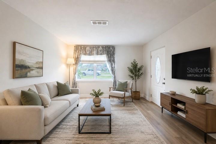This living room features a sofa, coffee table, armchair, and wall-mounted television — 314 4TH AVENUE SW, RUSKIN, FL
