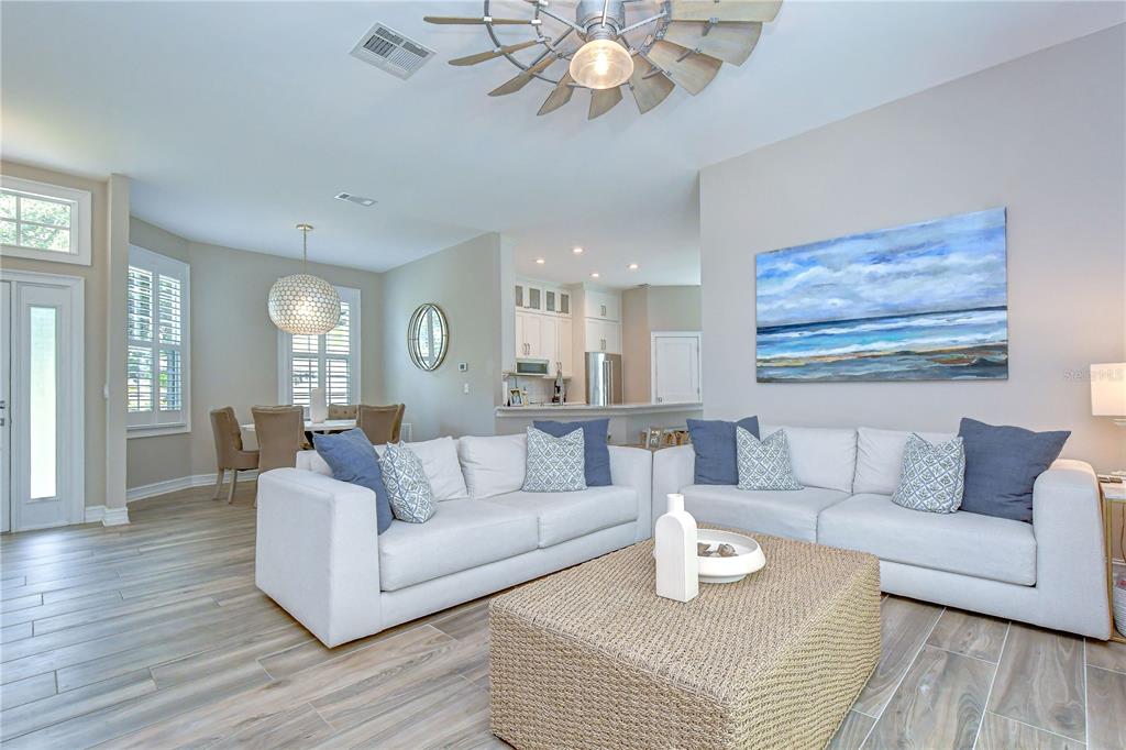 A living room with a white sectional sofa, wicker coffee table, and windmill ceiling fan — 3530 FOX SQUIRREL LANE, VALRICO, FL